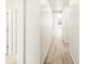 Inviting hallway with light wood flooring, freshly painted walls, and recessed lighting creates a modern, welcoming path at 6050 Hourglass Dr, Brighton, CO 80601