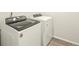 Laundry room with white Whirlpool washer and dryer at 6050 Hourglass Dr, Brighton, CO 80601