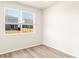 Bright spare bedroom with large window and hardwood floors at 6050 Hourglass Dr, Brighton, CO 80601