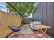 A red brick patio featuring outdoor seating, a bamboo fence, and various greenery at 3444 Lawrence St, Denver, CO 80205