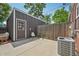 An outdoor patio featuring a small chair, and an AC unit, a wooden fence and a backdoor entrance at 3444 Lawrence St, Denver, CO 80205