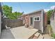 A concrete patio and wooden fence in a backyard that also features a small chair and stool at 3444 Lawrence St, Denver, CO 80205
