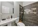 A modern bathroom features a stylish vanity, toilet, and an elegant shower with unique tile work at 3444 Lawrence St, Denver, CO 80205