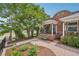 A well-maintained brick home has a spacious front yard with mature trees, landscaping, and a porch at 3444 Lawrence St, Denver, CO 80205