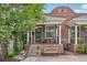 Charming brick home with a covered front porch, landscaped yard, and mature trees at 3444 Lawrence St, Denver, CO 80205