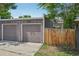 A grey garage and wooden fence with some greenery in a backyard at 3444 Lawrence St, Denver, CO 80205