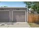 A grey garage and wooden fence with some greenery in a backyard at 3444 Lawrence St, Denver, CO 80205