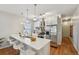 Bright kitchen features stainless appliances, white cabinets, and large center island with bar seating at 3444 Lawrence St, Denver, CO 80205