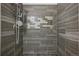 A detailed close up shows a modern tiled shower with decorative tiling and a stone floor at 3444 Lawrence St, Denver, CO 80205