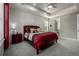 Bedroom with tray ceiling, neutral carpet, and a red-themed comforter set at 8230 S White Crow St, Aurora, CO 80016