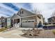 Inviting home with two-car garage, manicured lawn, stone and siding details and concrete stairs to front entry at 8230 S White Crow St, Aurora, CO 80016