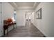Long, bright hallway featuring tray ceiling, wood floors and neutral paint, leading to other rooms at 8230 S White Crow St, Aurora, CO 80016