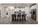 A kitchen island with seating, white cabinets, stainless steel appliances, and wood flooring at 8230 S White Crow St, Aurora, CO 80016