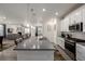 Modern kitchen island with stainless steel appliances, white cabinets, and dining area at 8230 S White Crow St, Aurora, CO 80016