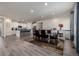 Open floor plan with kitchen, dining area with table, and wood-look flooring at 8230 S White Crow St, Aurora, CO 80016