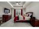 Comfortable main bedroom with a coffered ceiling, fan, flat screen TV, and stylish, neutral-toned decor at 8230 S White Crow St, Aurora, CO 80016