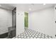 Bright bathroom features a modern shower with striking geometric tile flooring at 5200 W Rowland Ave, Littleton, CO 80128