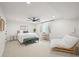 Bright bedroom with a ceiling fan, large bed, decorative bench, lounger and a sunny window at 5200 W Rowland Ave, Littleton, CO 80128
