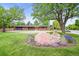 Stunning front exterior of a red brick home with mature landscaping and orange front door at 5200 W Rowland Ave, Littleton, CO 80128