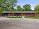 Charming red brick home with an orange front door and manicured front lawn at 5200 W Rowland Ave, Littleton, CO 80128