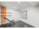 This modern gym features black tiled floor, white walls, wood accents, mirrors, and workout equipment at 5200 W Rowland Ave, Littleton, CO 80128