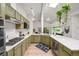 Bright kitchen features light-green cabinets, stainless appliances, and a spacious countertop at 5200 W Rowland Ave, Littleton, CO 80128