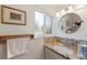 This bathroom has a granite vanity, a round mirror, and earth toned tile backsplash at 6040 Taft Ct, Arvada, CO 80004