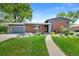 Inviting front exterior with well-manicured lawn, walkway, and attached garage on a sunny day at 6040 Taft Ct, Arvada, CO 80004