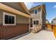 A fenced backyard includes a brick retaining wall, gray siding and a small deck at 14065 Harrison St, Thornton, CO 80602