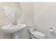 Powder bathroom featuring white pedestal sink, toilet and classic fixtures at 14065 Harrison St, Thornton, CO 80602