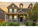 Inviting two-story home featuring a charming front porch, neutral siding, and lush landscaping at 14065 Harrison St, Thornton, CO 80602