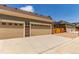 Two car garage has a beige facade with brick accents, a large driveway, and address numbers at 14065 Harrison St, Thornton, CO 80602