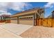 The two-car garage has a beige facade with brick accents and a large driveway at 14065 Harrison St, Thornton, CO 80602