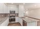 This kitchen is complete with modern appliances, granite counters, and white cabinets at 14065 Harrison St, Thornton, CO 80602