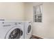 Convenient laundry room featuring a side-by-side washer and dryer, and natural light from the window at 14065 Harrison St, Thornton, CO 80602