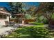 Lush backyard with a dining table and grill area under a pergola, perfect for entertaining outdoors at 5000 S Chester St, Greenwood Village, CO 80111