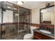 Bathroom featuring stone-tiled shower, black granite countertops, modern fixtures, and decorative mirror at 5000 S Chester St, Greenwood Village, CO 80111