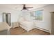 Bedroom with hardwood floors, soft pastel walls, a large window, and vintage furniture at 5000 S Chester St, Greenwood Village, CO 80111
