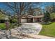 Inviting single-story home with mature trees, brick detailing, and a spacious driveway at 5000 S Chester St, Greenwood Village, CO 80111