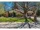 Well-maintained front yard featuring lush green grass, mature trees, and a charming brick single-story home at 5000 S Chester St, Greenwood Village, CO 80111