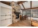 Living room highlighting stone fireplace, exposed beams, hardwood floors and built-in shelving at 5000 S Chester St, Greenwood Village, CO 80111