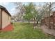 Spacious backyard featuring mature trees, a brick wall, well-maintained lawn, and a decorative windmill at 55 Emerald St, Broomfield, CO 80020