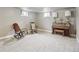 Basement features neutral carpet, two rocking chairs, and a piano at 55 Emerald St, Broomfield, CO 80020