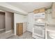 An eat-in kitchen area, with white appliances and light wooden cabinets, provides a cozy area to cook at 55 Emerald St, Broomfield, CO 80020