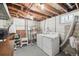 This laundry room has an exposed ceiling, concrete walls, and side by side washer and dryer units at 55 Emerald St, Broomfield, CO 80020