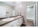 Bright bathroom featuring double sinks, a large mirror, and a separate shower area for added convenience at 12035 Fontberry St, Parker, CO 80134
