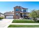 Beautiful two-story home with a stone facade, a two-car garage, a manicured lawn, and mature landscaping at 12035 Fontberry St, Parker, CO 80134