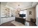 Well-lit home office featuring built-in shelving, custom desk, and contemporary decor at 12035 Fontberry St, Parker, CO 80134