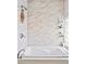 Modern bathroom features a soaking tub with marble-style tile surround, shower, and glass block window at 2565 Pierce St, Lakewood, CO 80214