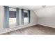 Bedroom featuring two windows with blue curtains and wood floors at 2565 Pierce St, Lakewood, CO 80214